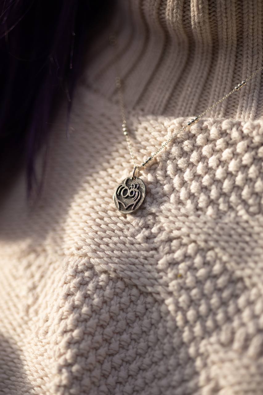 Objects pendant worn on a knit sweater